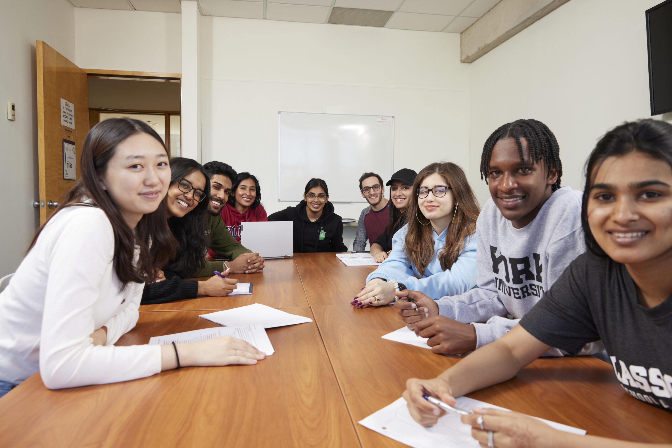 group of students smiling in a meeting