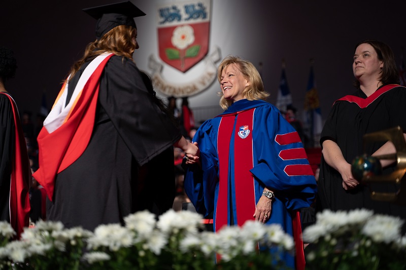 person shaking hands on graduation stage