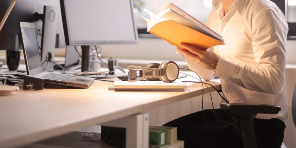 Student studying at a desk with their laptop and headphones in front of them.