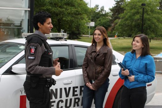 York University Security Services official chatting with students