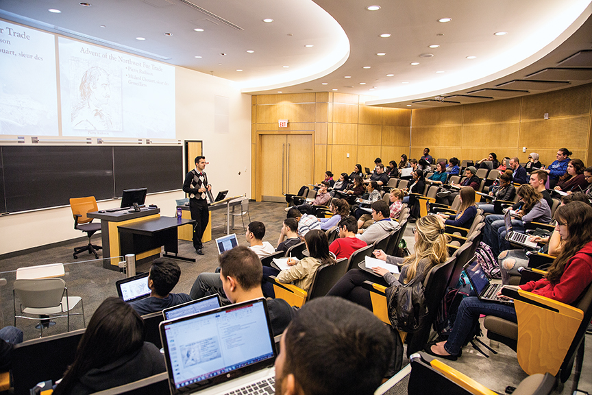 a students sitting in a lecture hall with a professor