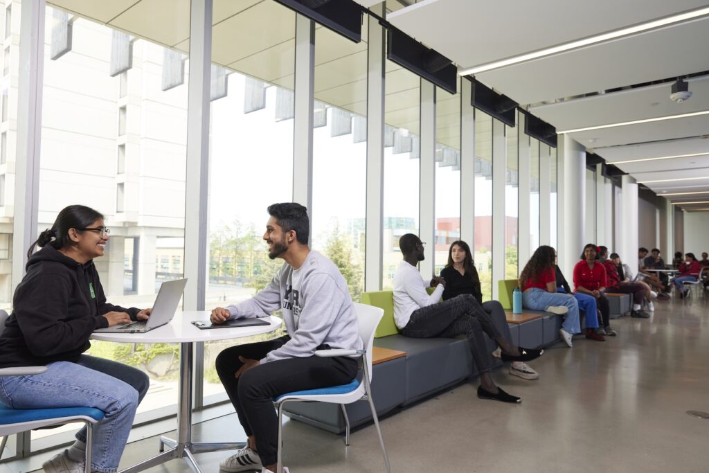 photo of different groups of people having conversations in small groups within a common area