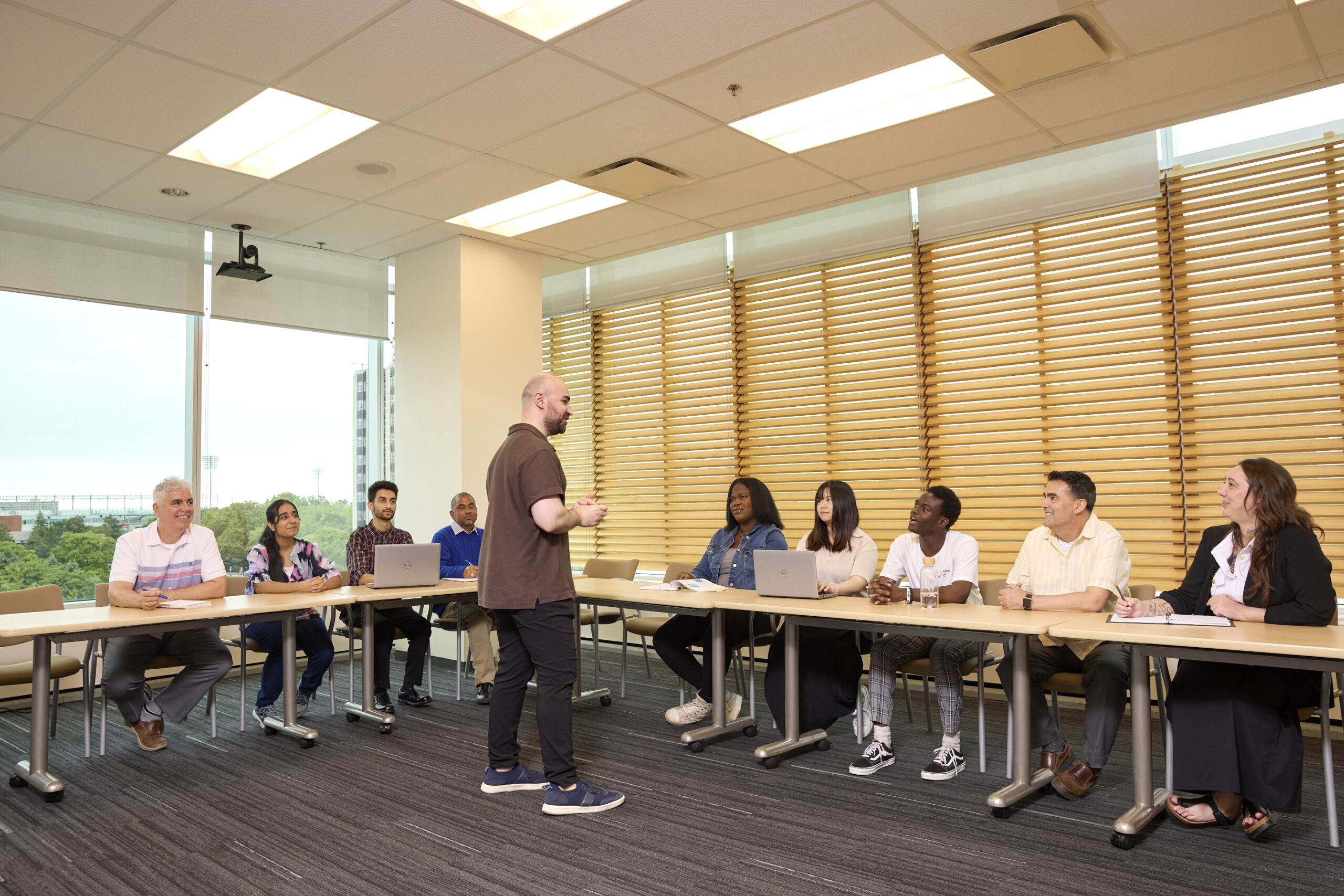 a speaker standing and giving a talk to students who are sitting