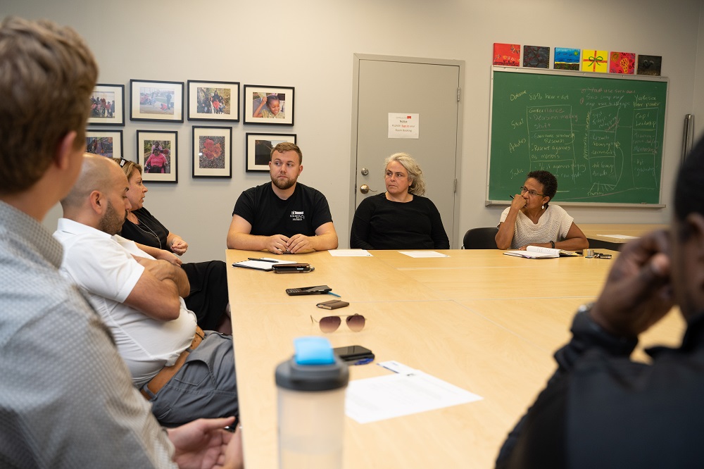 Group of people at a desk having a meeting