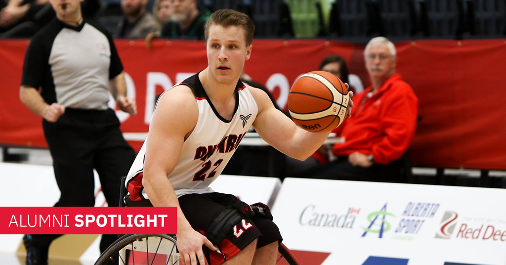 Erik Robeznieks (BSc ’19) in wheel chair wearing a basketball jersey and holding a basketball.