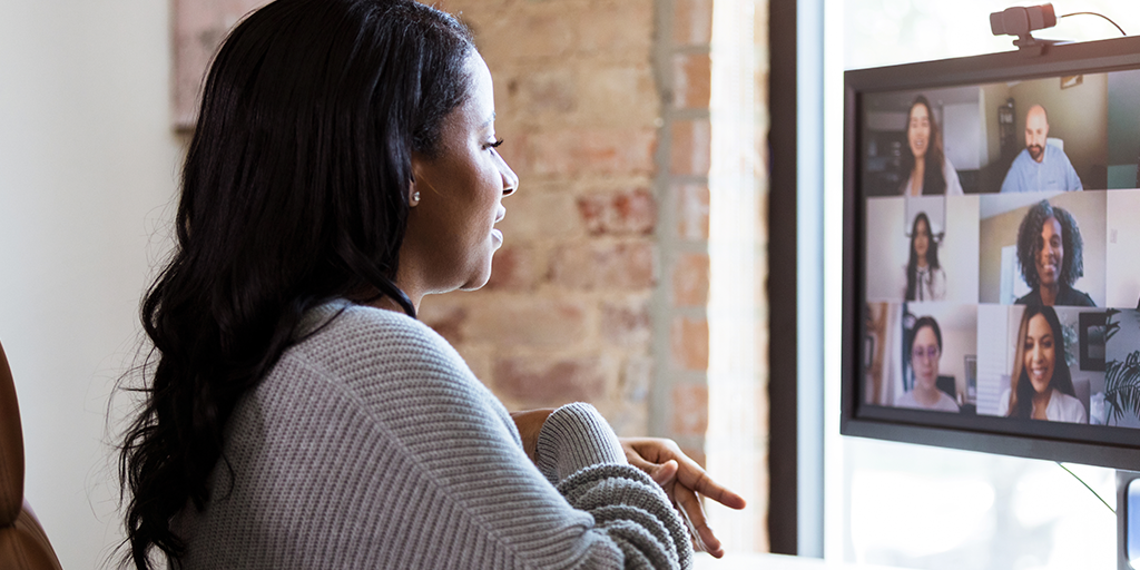 Woman seated at desk, participating in a video conference call or webinar